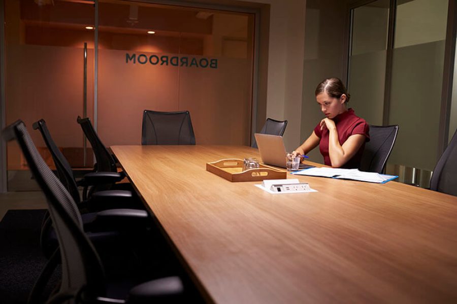 Young white businesswoman working alone late in an office